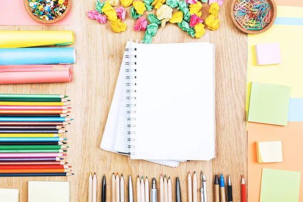 Wooden office desk top with colorful supplies — Stock Photo, Image