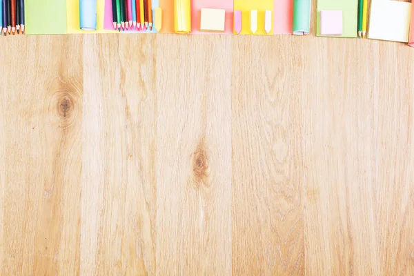 Wooden office desktop with colorful supplies — Stock Photo, Image