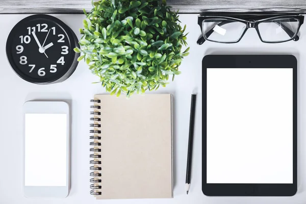 Modern desk with empty tablet and phone