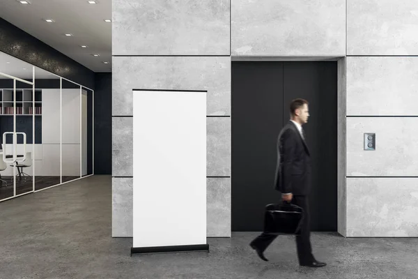 Man in kantoor met lift en poster — Stockfoto