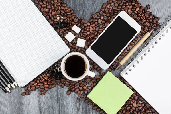 Lugar de trabajo de madera con teléfono inteligente y café — Foto de Stock