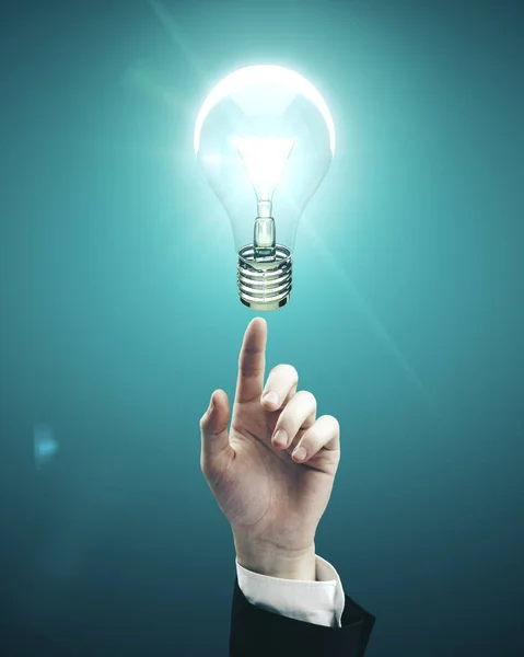 Hand pointing to light bulb — Stock Photo, Image