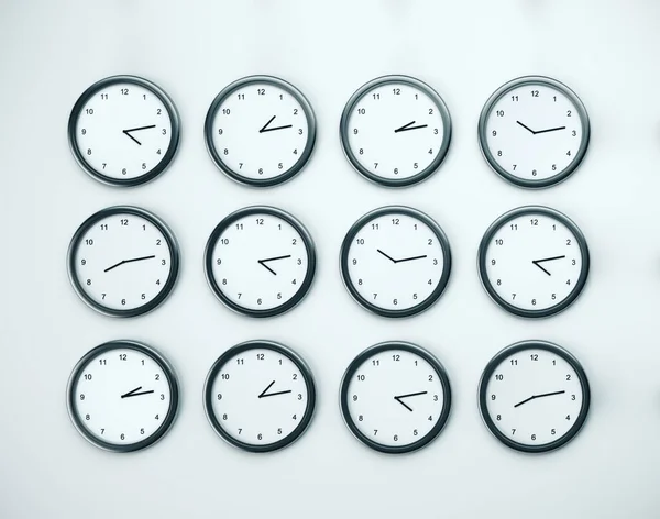 Muchos reloj en la pared blanca . — Foto de Stock