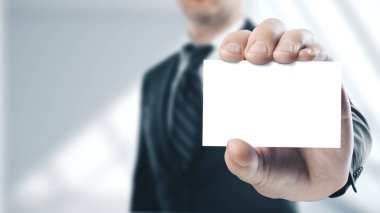 Beyaz bir kart tutan işadamı
