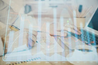 Arka planda dizüstü bilgisayar üzerinde çalışan adam ile borsa grafiği çoklu pozlama. Finansal analiz kavramı.