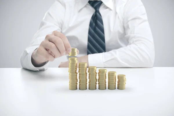 Empresário mão coloca moedas de ouro — Fotografia de Stock
