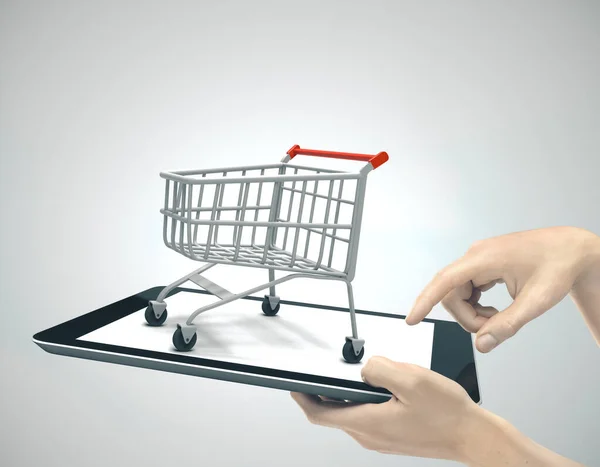 Hands holding a tablet with shopping cart — ストック写真