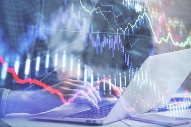 Arka planda bilgisayarda çalışan bir adamla piyasa grafiği iki katına çıktı. Mali analiz kavramı.