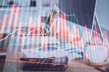 Finansal pazar grafiği hologramı ve kişisel bilgisayar arka planda. Çoklu maruz kalma. Önx kavramı.