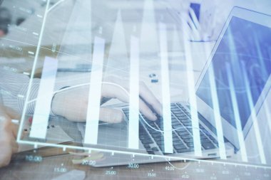 Arka planda dizüstü bilgisayar üzerinde çalışan adam ile borsa grafiği çoklu pozlama. Finansal analiz kavramı.