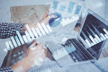 Dizüstü bilgisayar ve borsa grafik arka plan ile işadamları nın ellerini çift pozlama. Araştırma ve ticaret kavramı.