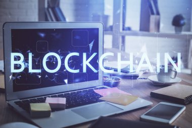 Blockchain temalı holograma ve bilgisayar arkaplanlı masaya çoklu maruz kalma. Bitcoin şifreleme para birimi kavramı.
