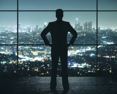 İşadamı gece ofisinde duruyor.