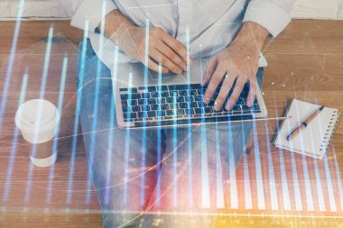 Forex grafik arka plan ile borsa dizüstü bilgisayar ile notlar yazma adamın ellerini çift pozlama. Üst Görünüm. Araştırma ve ticaret kavramı.