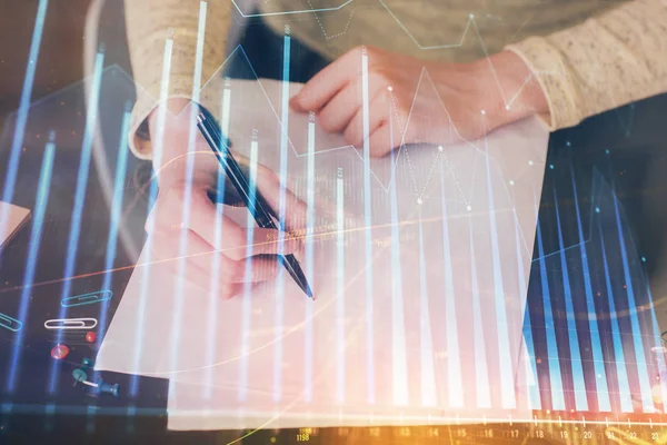 Toma de notas a mano en bloc de notas. Hologramas gráfico de divisas en frente. Concepto de investigación. Exposición múltiple —  Fotos de Stock