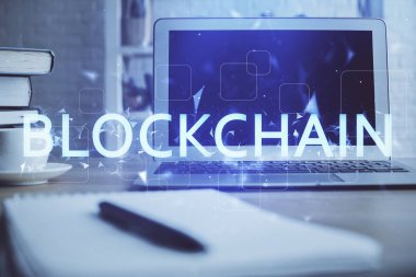 Blockchain temalı holograma ve bilgisayar arkaplanlı masaya çoklu maruz kalma. Bitcoin şifreleme para birimi kavramı.