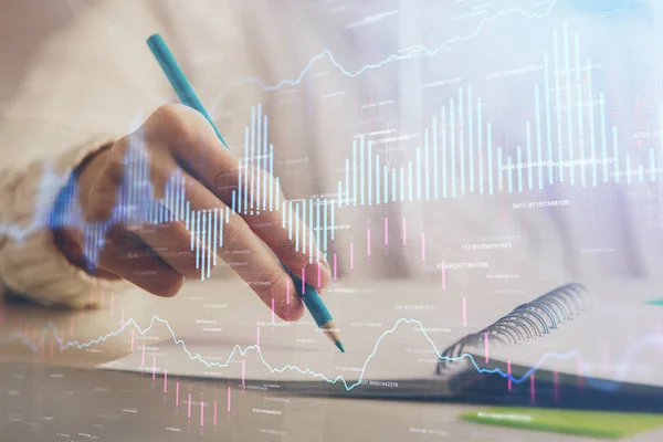 Gráfico de divisas financieras que se muestran en las manos tomando notas de fondo. Concepto de investigación. Doble exposición — Foto de Stock