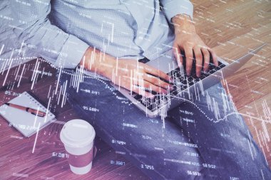 Forex grafik arka plan ile borsa dizüstü bilgisayar ile notlar yazma adamın ellerini çift pozlama. Üst Görünüm. Araştırma ve ticaret kavramı.