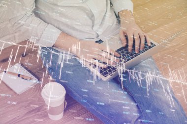 Dizüstü bilgisayar ve borsa grafik arka plan ile işadamının ellerini çift pozlama. Araştırma ve ticaret kavramı.