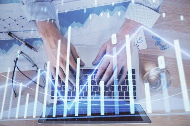 Arka planda bilgisayarda çalışan bir adamla piyasa grafiği iki katına çıktı. Mali analiz kavramı.