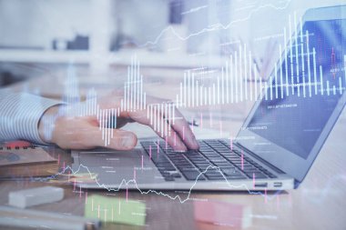 Arka planda dizüstü bilgisayar üzerinde çalışan adam ile borsa grafiği çift pozlama. Finansal analiz kavramı.
