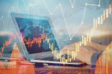 Arka planda bilgisayar üzerinde çalışan bir adamla birlikte çok sayıda piyasa haritasına maruz kaldık. Mali analiz kavramı.