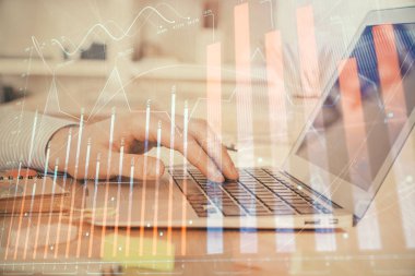 Arka planda dizüstü bilgisayar üzerinde çalışan adam ile borsa grafiği çift pozlama. Finansal analiz kavramı.