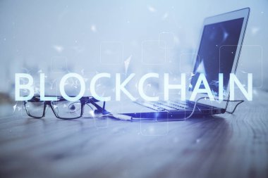 Blockchain temalı holograma ve bilgisayar arkaplanlı masaya çoklu maruz kalma. Bitcoin şifreleme para birimi kavramı.