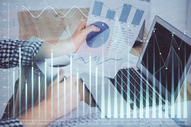 Arka planda bilgisayar üzerinde çalışan bir adamla birlikte çok sayıda piyasa haritasına maruz kaldık. Mali analiz kavramı.