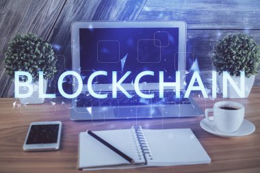 Blockchain temalı holograma ve bilgisayar arkaplanlı masaya çoklu maruz kalma. Bitcoin şifreleme para birimi kavramı.