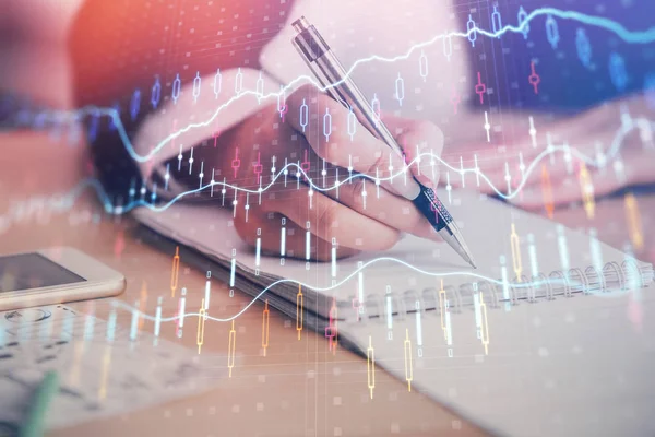 A woman hands writing information about stock market in notepad. Forex chart holograms in front. Concept of research. Multi exposure — Stock Photo, Image