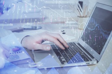 Arka planda dizüstü bilgisayar üzerinde çalışan adam ile borsa grafiği çift pozlama. Finansal analiz kavramı.