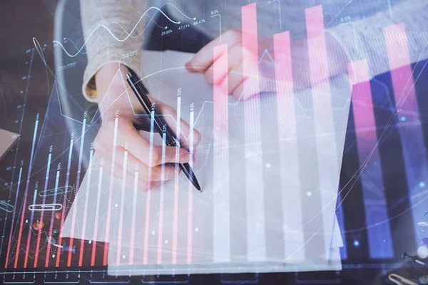 Toma de notas a mano en bloc de notas. Hologramas gráfico de divisas en frente. Concepto de investigación. Exposición múltiple —  Fotos de Stock