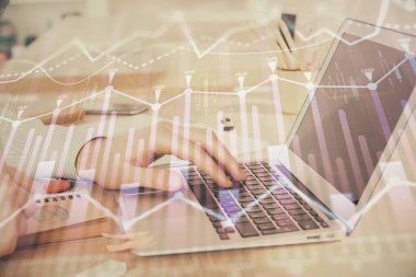 Arka planda dizüstü bilgisayar üzerinde çalışan adam ile borsa grafiği çift pozlama. Finansal analiz kavramı.