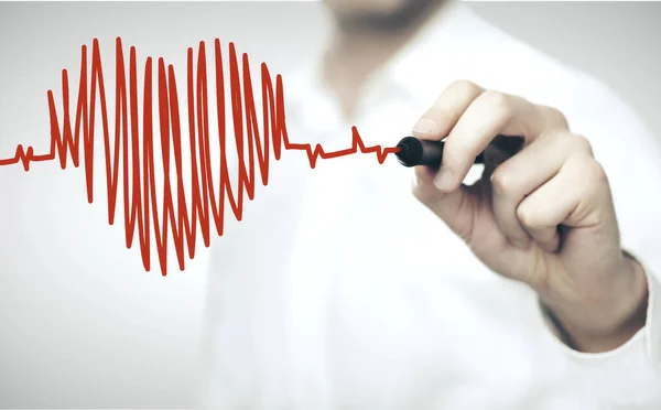 Doctor drawing red heart symbol — Stock Photo, Image