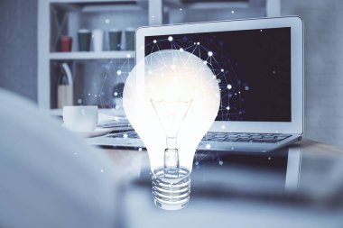 Bilgisayar ofisinde ampul simgesi hologramıyla birlikte. Çoklu maruz kalma. Fikir kavramı.
