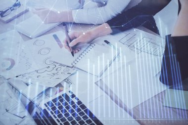 Bir kadın eller Not defteri hisse senedi piyasası hakkında bilgi yazma. Ön Forex grafik hologramlar. Araştırma kavramı. Çift Pozlama