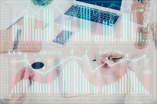 메모장에 주식 시장에 대한 정보를 쓰는 손. 앞에 외환 차트 홀로그램. 연구의 개념. 다중 노출 — 스톡 사진