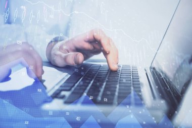 Arka planda bilgisayarda çalışan bir adamla piyasa grafiği iki katına çıktı. Mali analiz kavramı.