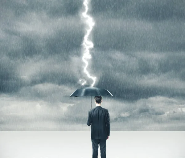 Empresario sosteniendo paraguas en tormenta . — Foto de Stock