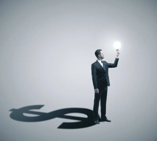 Businessman holding glowing lightbulb — Stock Photo, Image
