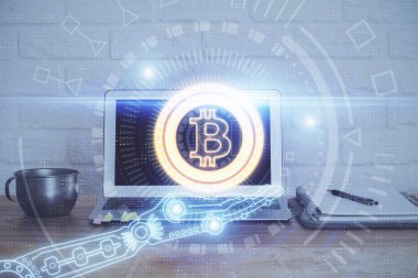 Blockchain temalı holograma ve bilgisayar arkaplanlı masaya çift pozlama. Bitcoin şifreleme para birimi kavramı.