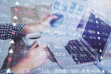 Arka planda ofiste bilgisayarda işadamı yazarak stok grafik çift pozlama. Zor iş kavramı.