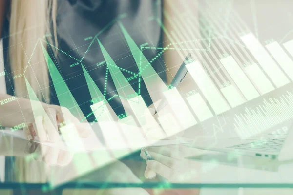 A woman hands writing information about stock market in notepad. Forex chart holograms in front. Concept of research. Double exposure — Stock Photo, Image