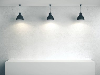 Boş beton duvar, podyum ve üç lamba.