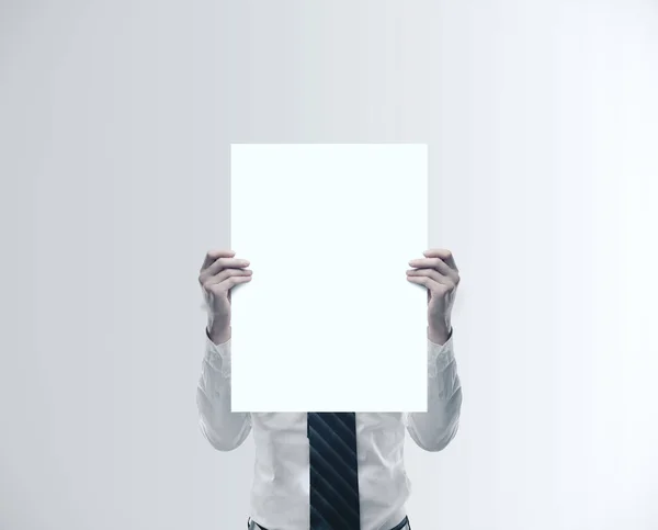 Uomo d'affari in possesso di manifesto bianco vuoto — Foto Stock