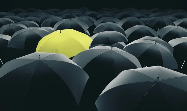 Жовта парасолька в масі чорних парасольок . — стокове фото