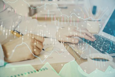 Arka planda dizüstü bilgisayar üzerinde çalışan adam ile borsa grafiği çoklu pozlama. Finansal analiz kavramı.