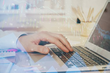 Arka planda dizüstü bilgisayar üzerinde çalışan adam ile borsa grafiği çift pozlama. Finansal analiz kavramı.