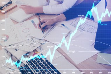 Bir kadın eller Not defteri hisse senedi piyasası hakkında bilgi yazma. Ön Forex grafik hologramlar. Araştırma kavramı. Çift Pozlama